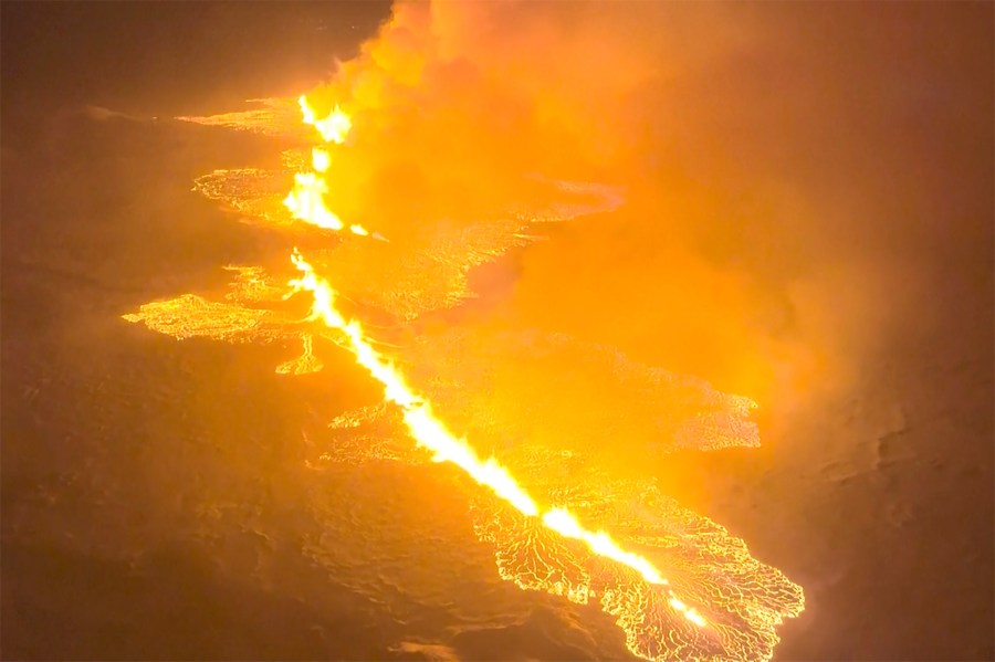 This image made from video provided by the Icelandic Coast Guard shows magma flow on a hill near Grindavik on Iceland's Reykjanes Peninsula sometime around late Monday, Dec. 18, or early Tuesday, Dec. 19, 2023. A volcanic eruption started Monday night on Iceland's Reykjanes Peninsula, turning the sky orange and prompting the country's civil defense to be on high alert. (Icelandic coast guard via AP)