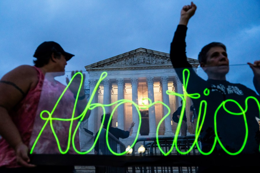 FILE - Activists mark the first anniversary of the Supreme Court's decision in Dobbs v. Jackson Women's Health Organization by displaying neon signage in support of abortion access, June 23, 2023, in Washington. Ever since the nation’s highest court ended abortion rights more than a year ago by overturning Roe v. Wade, vaguely worded bans enacted in some Republican-controlled states have caused bewilderment over how exceptions should be applied. (AP Photo/Nathan Howard, File)