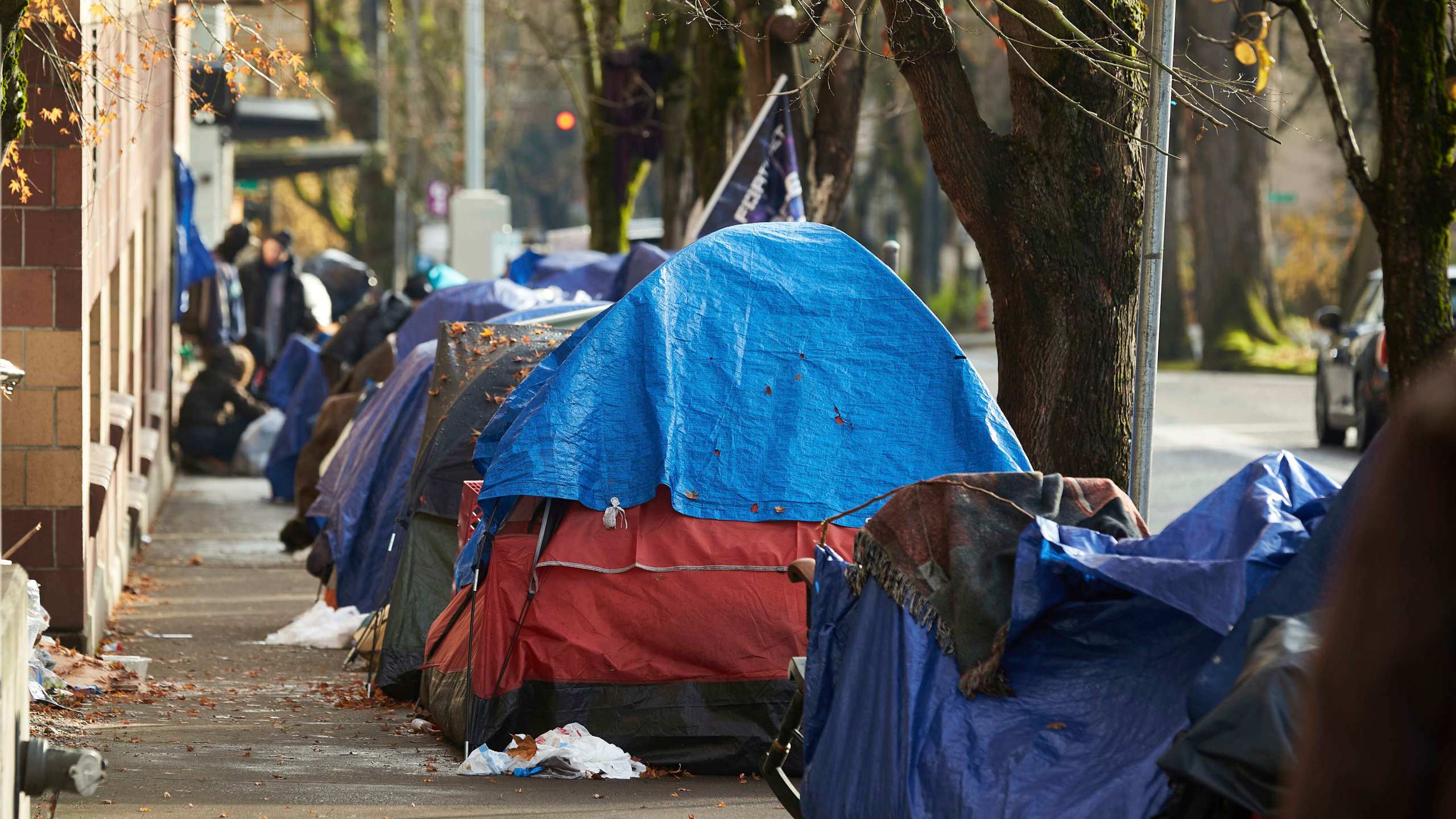 FILE - Tents line the sidewalk on SW Clay St in Portland, Ore., Dec. 9, 2020. According to an annual report released by regional officials Wednesday, Dec. 20, 2023, fentanyl and methamphetamine drove a record number of homeless deaths last year in Oregon's Multnomah County, home to Portland. (AP Photo/Craig Mitchelldyer, File)