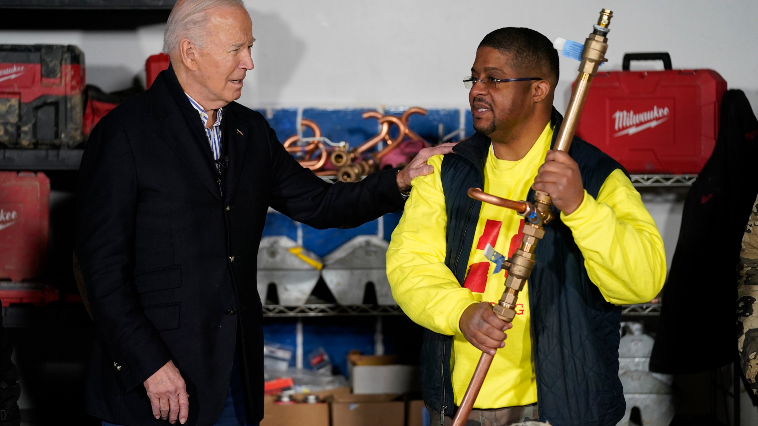 President Joe Biden speaks with Rashawn Spivey, CEO of Hero Plumbing, LLC as he visits Hero Plumbing on Wednesday, Dec. 20, 2023, in Milwaukee. (AP Photo/Evan Vucci)