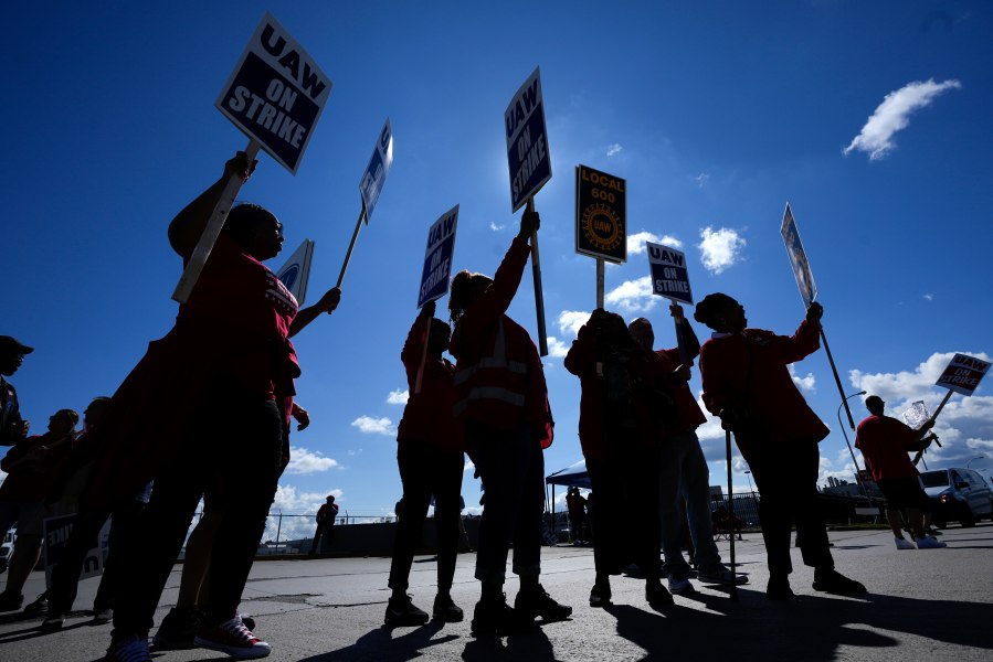 File - United Auto Workers members walk the picket line at the Ford Michigan Assembly Plant in Wayne, Mich., Sept. 18, 2023. The long-battered American labor movement flexed its muscle in 2023, taking advantage of widespread worker shortages to demand – and get -- better pay and benefits. (AP Photo/Paul Sancya, File)