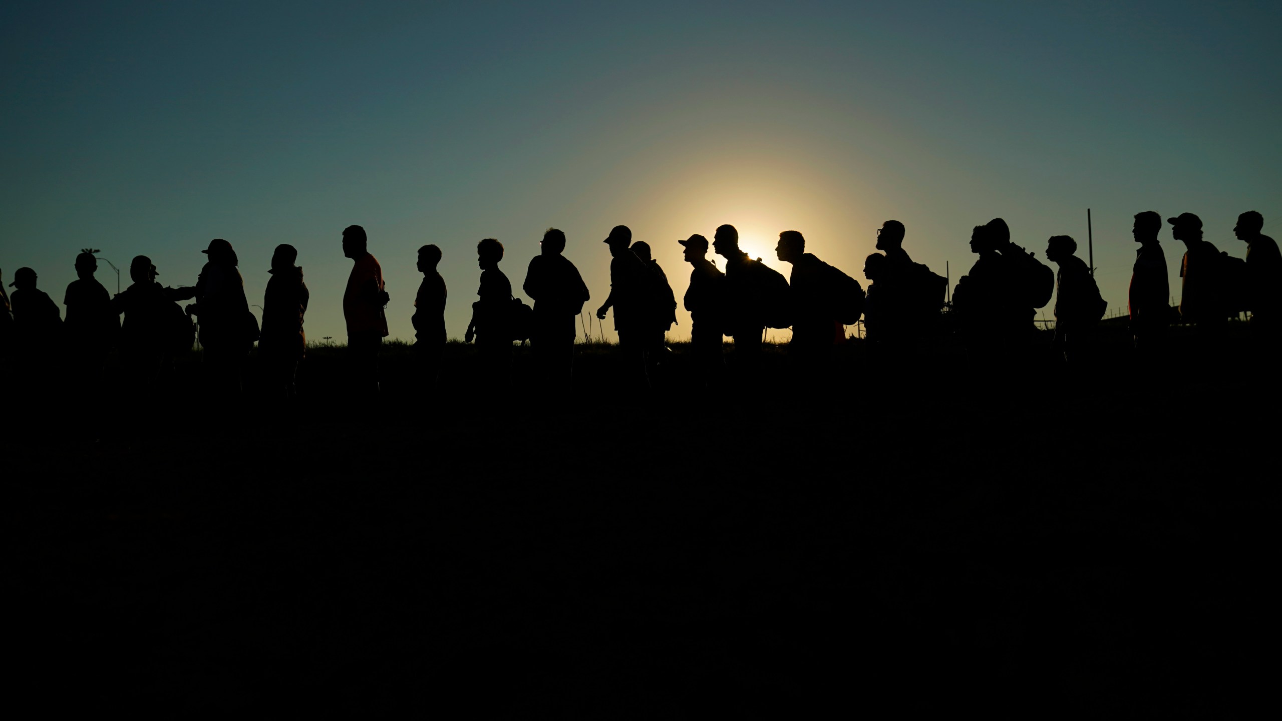 FILE - Migrants who crossed the Rio Grande and entered the U.S. from Mexico are lined up for processing by U.S. Customs and Border Protection, Sept. 23, 2023, in Eagle Pass, Texas. Texas began flying migrants from the U.S.-Mexico border to Chicago on Wednesday, Dec. 20, a week after the city took a tougher stance on the buses that Republican Gov. Greg Abbott has been sending north since last year. (AP Photo/Eric Gay, File)