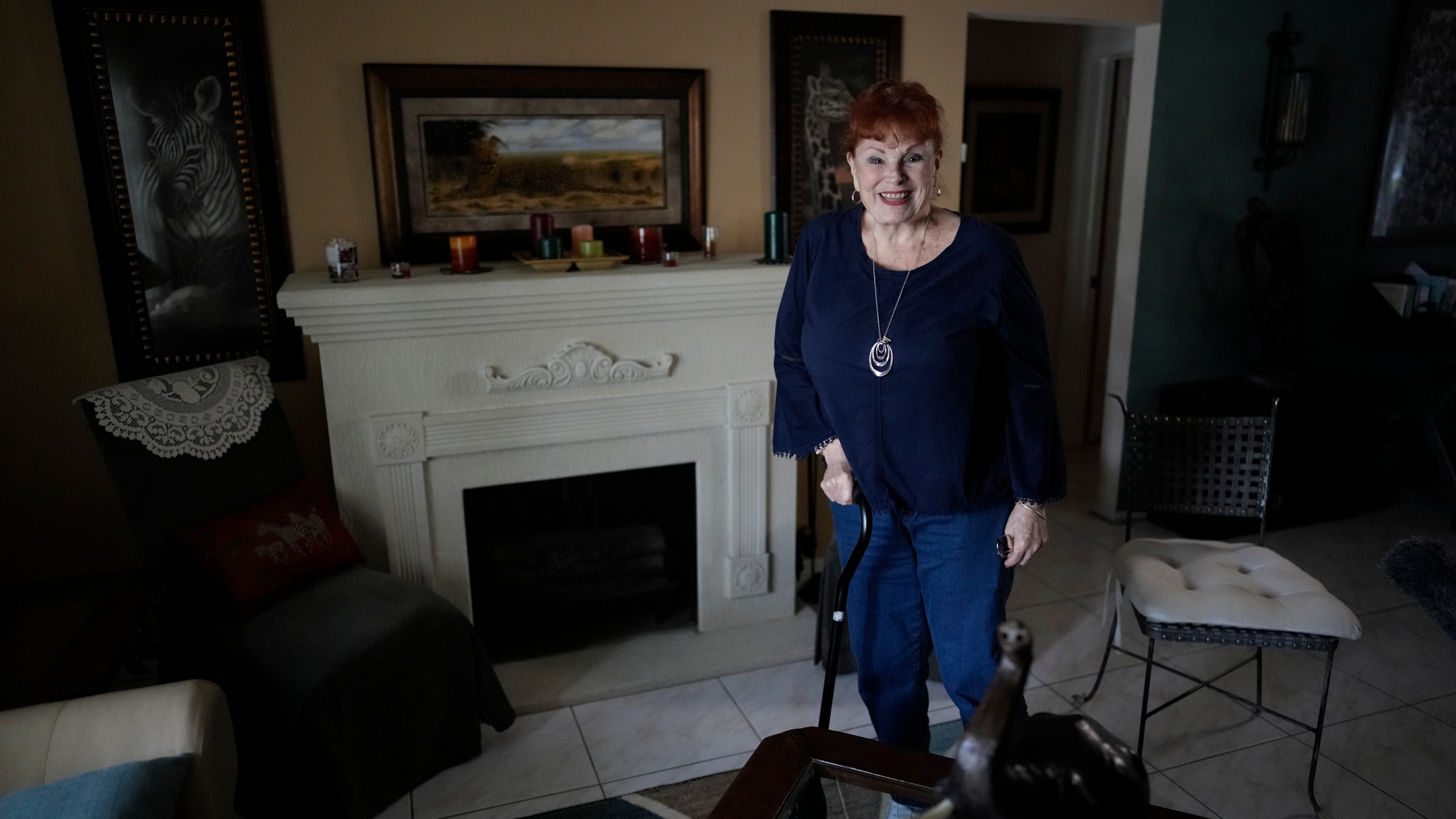 Deanna Dezern, 83, walks inside her home in Tamarac, Fla., Thursday, Dec. 7, 2023. Dezern is among the first in the country to receive the robot ElliQ, whose creators, Intuition Robotics, and senior assistance officials say is the only device using artificial intelligence specifically designed to lessen the loneliness and isolation experienced by many older Americans. (AP Photo/Rebecca Blackwell)