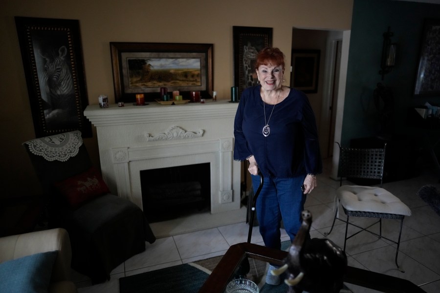 Deanna Dezern, 83, walks inside her home in Tamarac, Fla., Thursday, Dec. 7, 2023. Dezern is among the first in the country to receive the robot ElliQ, whose creators, Intuition Robotics, and senior assistance officials say is the only device using artificial intelligence specifically designed to lessen the loneliness and isolation experienced by many older Americans. (AP Photo/Rebecca Blackwell)