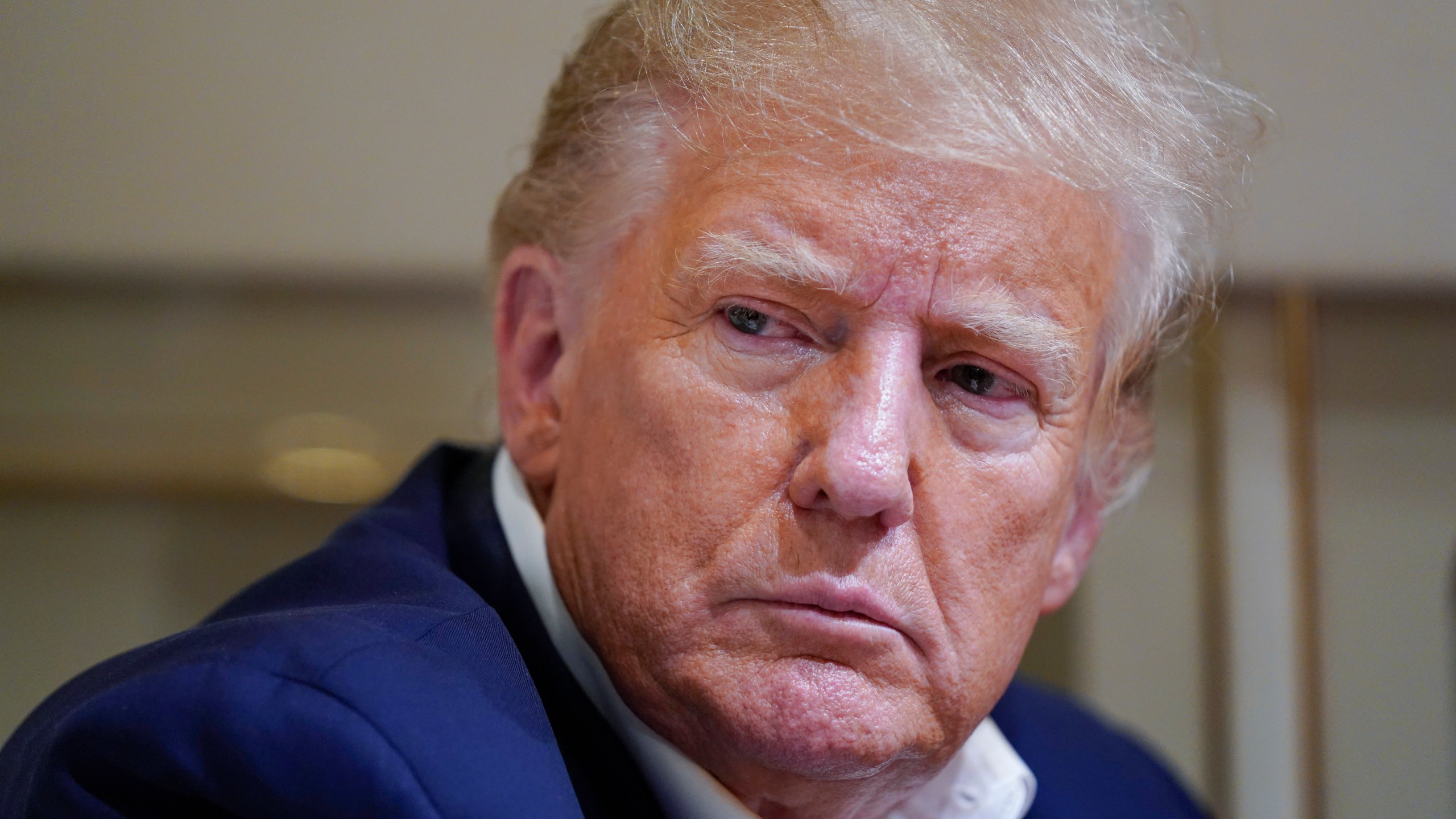 FILE - Former President Donald Trump listens as he speaks with reporters while in flight on his plane after a campaign rally at Waco Regional Airport, in Waco, Texas, March 25, 2023, while en route to West Palm Beach, Fla. Trump is facing criticism for repeatedly harnessing rhetoric once used by Adolf Hitler to argue that immigrants entering the U.S. illegally are “poisoning the blood of our country. Trump insists he had no idea that one of the world’s most reviled and infamous figures once used similar words. (AP Photo/Evan Vucci, File)