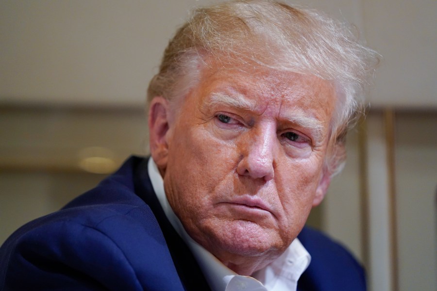 FILE - Former President Donald Trump listens as he speaks with reporters while in flight on his plane after a campaign rally at Waco Regional Airport, in Waco, Texas, March 25, 2023, while en route to West Palm Beach, Fla. Trump is facing criticism for repeatedly harnessing rhetoric once used by Adolf Hitler to argue that immigrants entering the U.S. illegally are “poisoning the blood of our country. Trump insists he had no idea that one of the world’s most reviled and infamous figures once used similar words. (AP Photo/Evan Vucci, File)