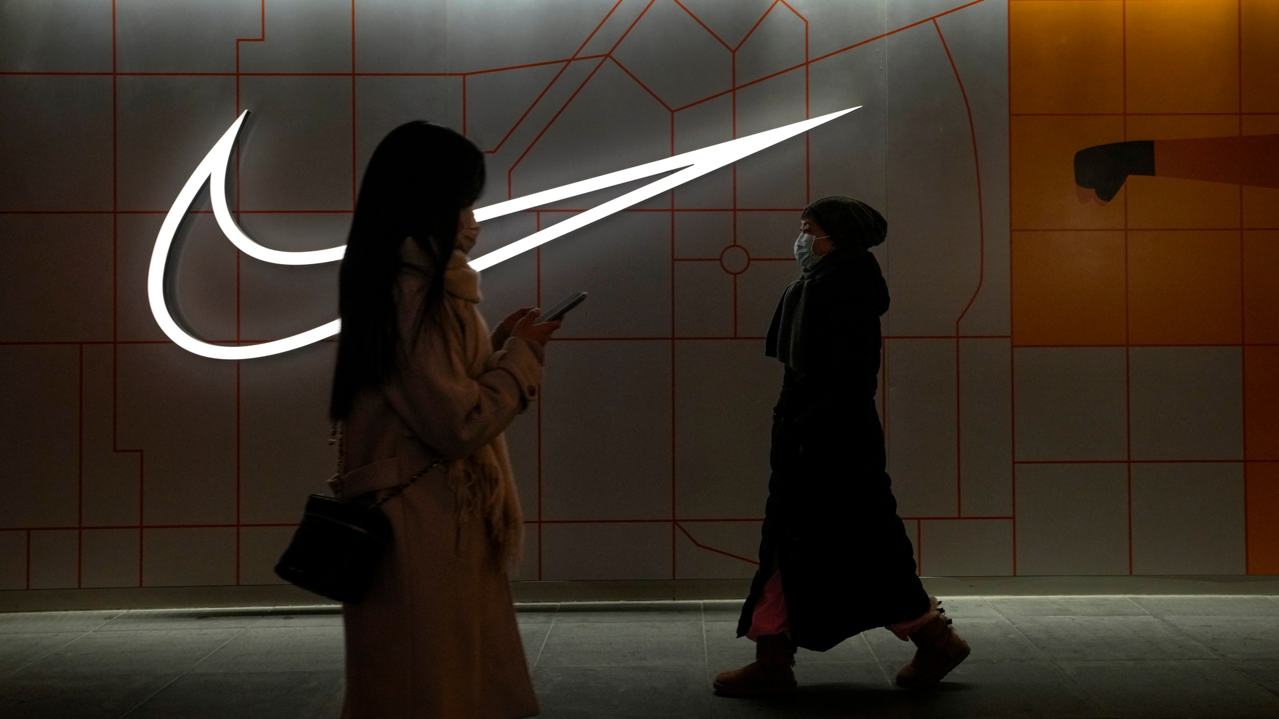 Women walk by a Nike Store at an outdoor shopping mall in Beijing on Saturday, Dec. 23, 2023. It was tumultuous 2023 for the Chinese economy. Some of the world's biggest brands said they were weighing, or already have decided, to shift manufacturing away from China amid unease about security controls, government protection of their Chinese rivals and Beijing's wobbly relations with Washington. But there was at least one bright spot for Beijing amid all the tough news about declining foreign investment: American fast food companies have announced a surge of investment in a market of 1.4 billion people. KFC, McDonald's and Starbucks are among companies in recent months that have announced plans for major investment in China. (AP Photo/Andy Wong)