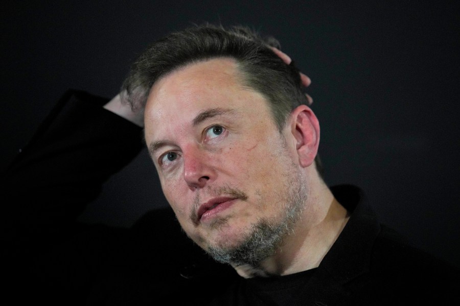 FILE - Elon Musk reacts during an in-conversation event with Britain's Prime Minister Rishi Sunak in London, on Nov. 2, 2023. A little more than a year ago, Elon Musk walked into Twitter's San Francisco headquarters, fired its CEO and other top executives and began transforming the social media platform into what's now known as X. (AP Photo/Kirsty Wigglesworth, Pool, File)