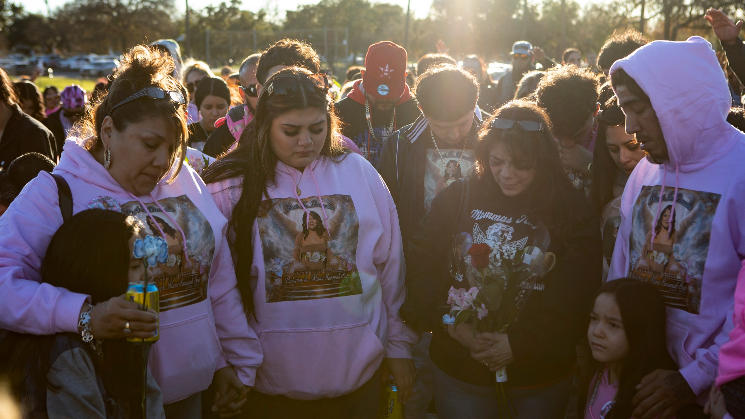 Vigil attendees pray over Savanah's family members (left to right) Serenity Corona, Laura Cordova, Joanie Wasil, Gloria Cordova, Stasia Corona, and Gerald Corona at a vigil for Savanah Soto, 18, and her unborn baby Fabian at Kenwood Park on Thursday, Dec. 28, 2023 in San Antonio, Texas. Authorities say Soto and Guerra were found earlier this week with gunshot wounds in a car and may have been dead for days. (Salgu Wissmath/The San Antonio Express-News via AP)