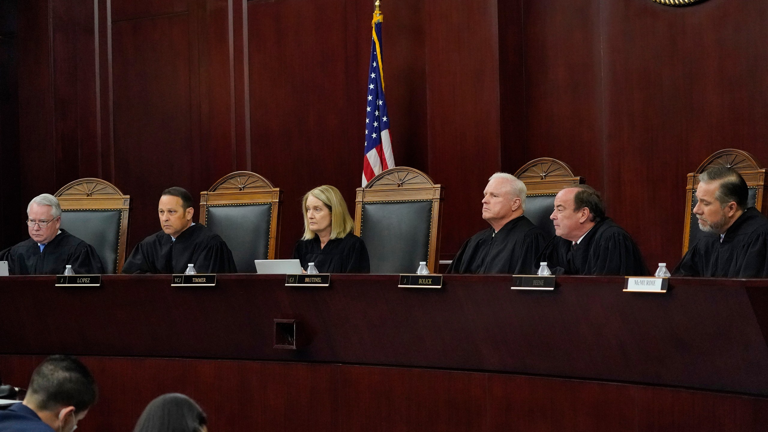 FILE - Arizona Supreme Court Justices from left; William G. Montgomery, John R Lopez IV, Vice Chief Justice Ann A. Scott Timmer, Chief Justice Robert M. Brutinel, Clint Bolick and James Beene listen to oral arguments on April 20, 2021, in Phoenix. (AP Photo/Matt York, File)