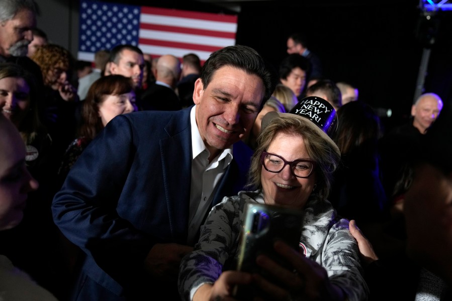 Republican presidential candidate Florida Gov. Ron DeSantis greets audience members during a New Year's Eve campaign event, Sunday, Dec. 31, 2023, in West Des Moines, Iowa. (AP Photo/Charlie Neibergall)