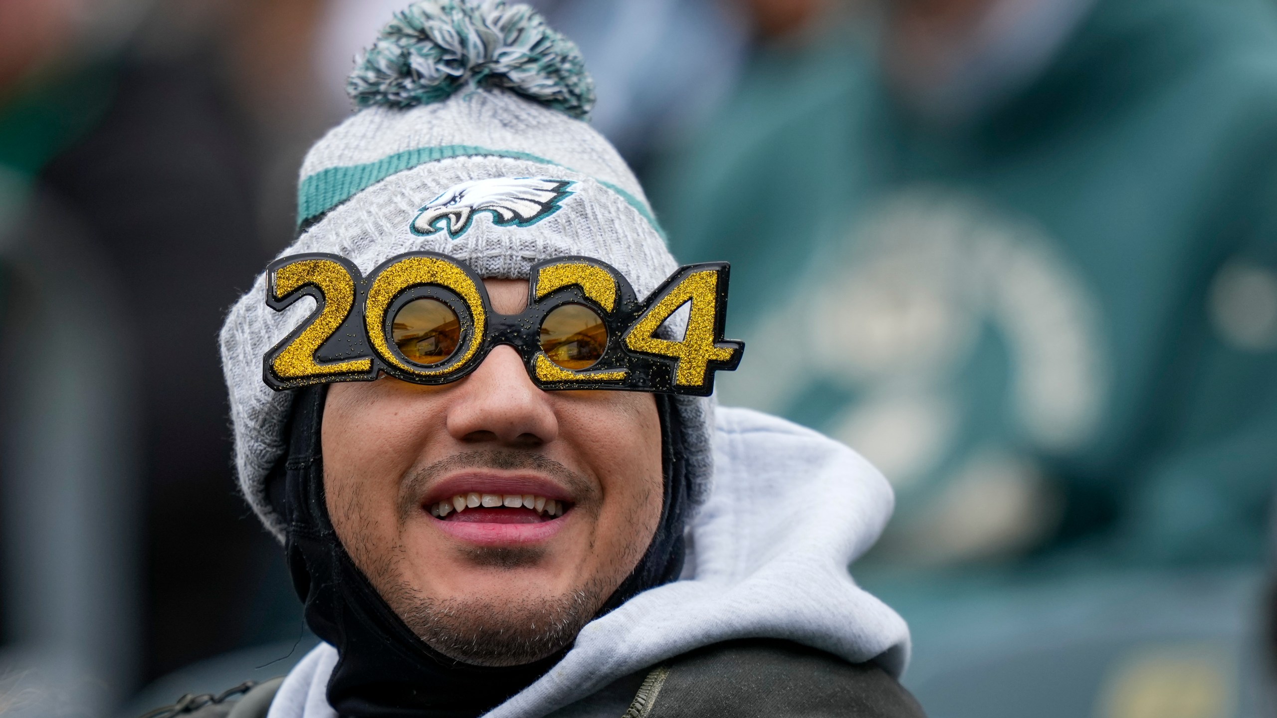 A spectator wears 2024 glasses in honor of the New Year prior to an NFL football game between the Philadelphia Eagles and the Arizona Cardinals, Sunday, Dec. 31, 2023, in Philadelphia. (AP Photo/Matt Slocum)