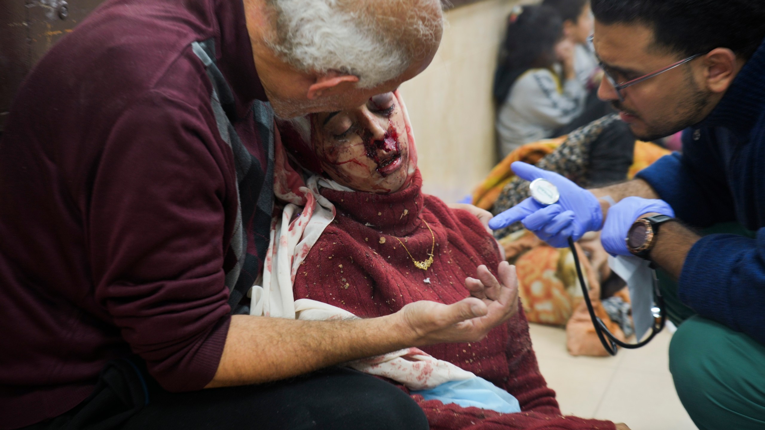 Palestinians wounded in Israeli bombardment are helped in a hospital in Deir al Balah, Monday, Jan. 1, 2024. (AP Photo/Hatem Moussa)