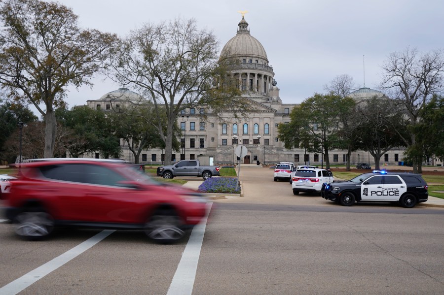 Traffic rolls past the Mississippi State Capitol in Jackson, Miss., as Capitol Police respond to a bomb threat within the building, Wednesday mornin, Jan. 3, 2024. The building was emptied, the grounds cleared of vehicles as officers investigated. (AP Photo/Rogelio V. Solis)