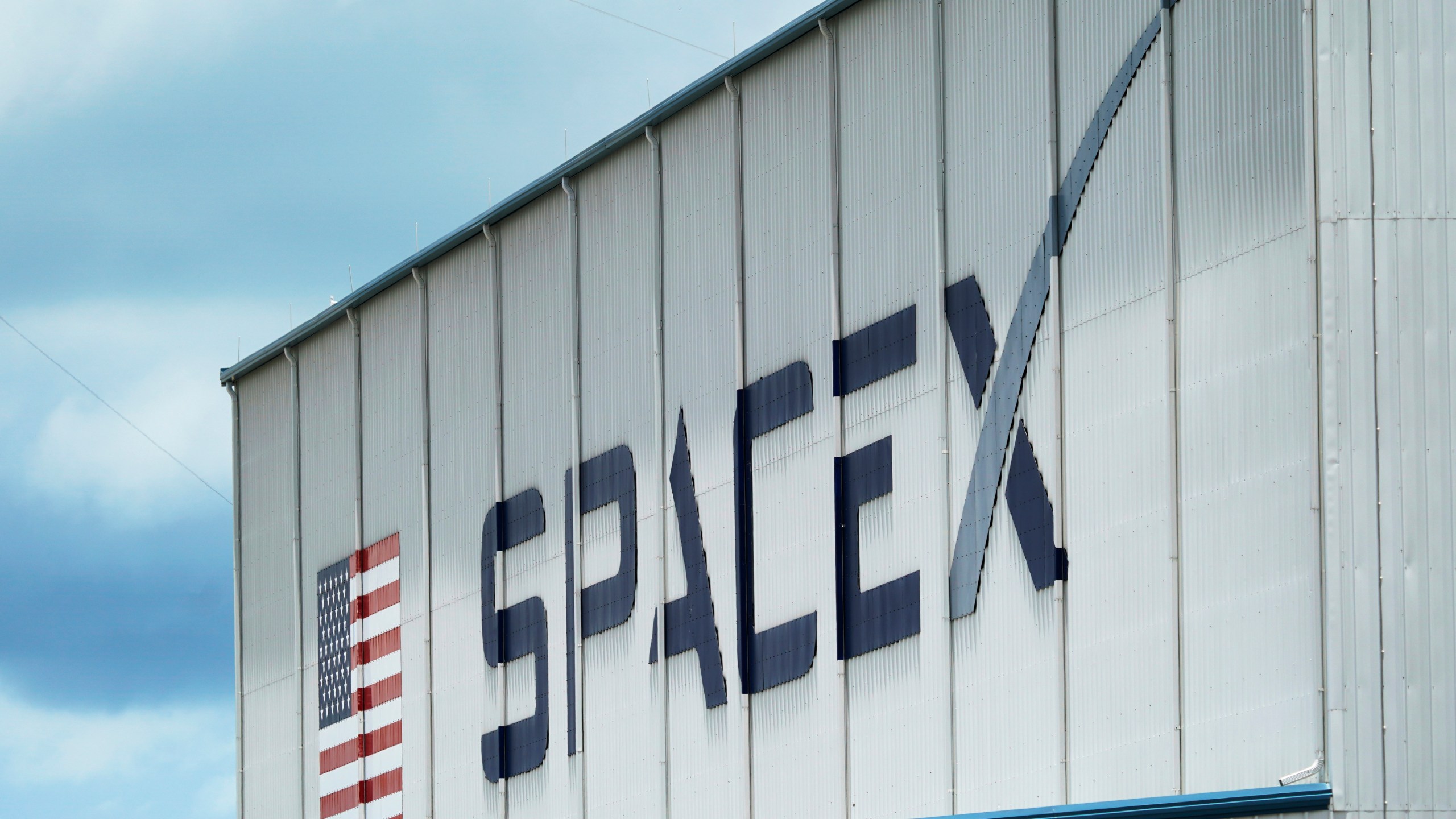 FILE - The SpaceX logo is displayed on a building, May 26, 2020, at the Kennedy Space Center in Cape Canaveral, Fla. On Wednesday, Jan. 3, 2024, a U.S. labor agency accused SpaceX of unlawfully firing employees who penned an open letter critical of CEO Elon Musk and creating an impression that worker activities were under surveillance by the rocket ship company. (AP Photo/David J. Phillip, File)