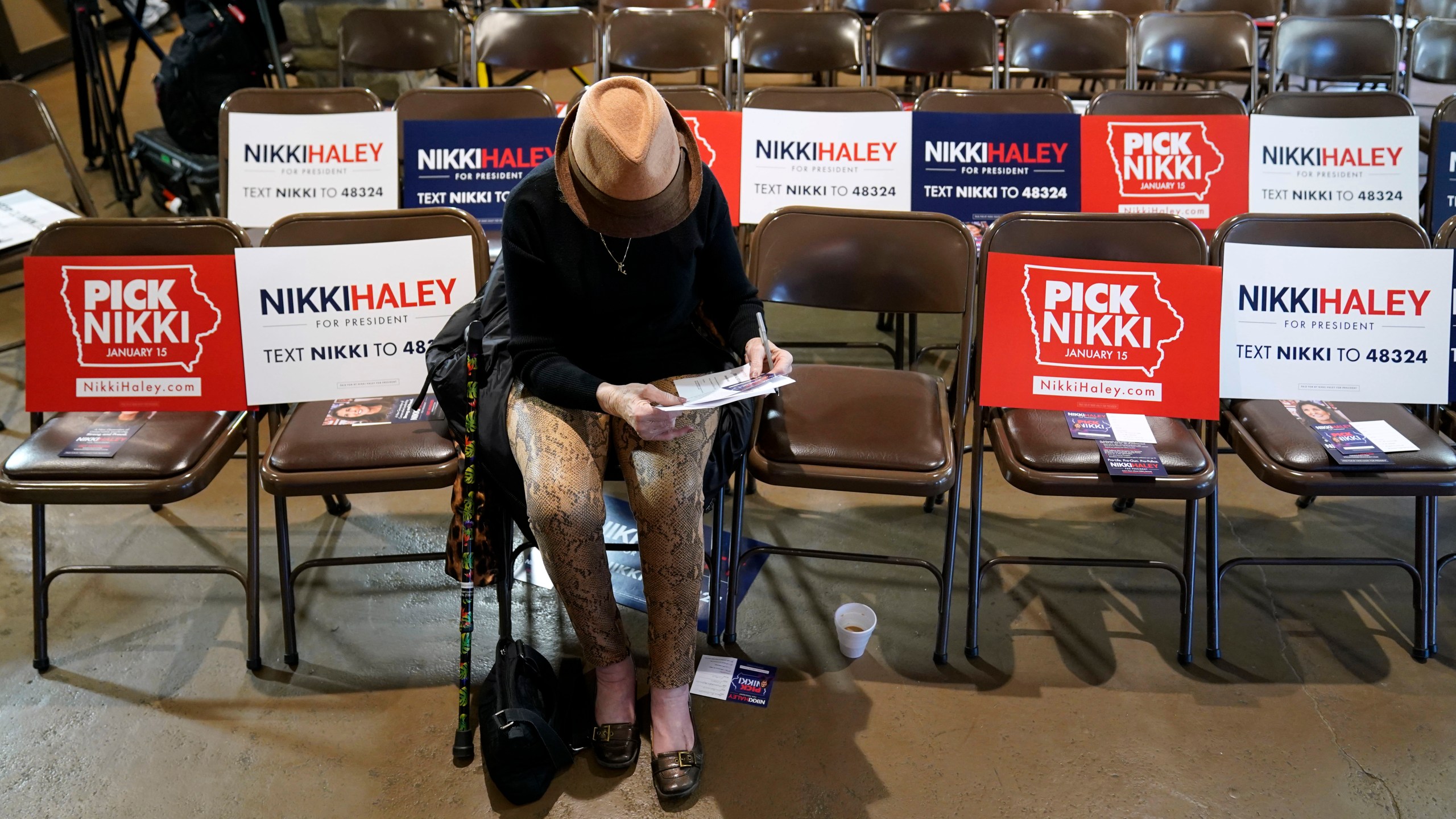 Sandra Sandfort, of Ames, Iowa, signs a commit to caucus card before a Republican presidential candidate Nikki Haley town hall, Monday, Dec. 18, 2023, in Nevada, Iowa. (AP Photo/Charlie Neibergall)