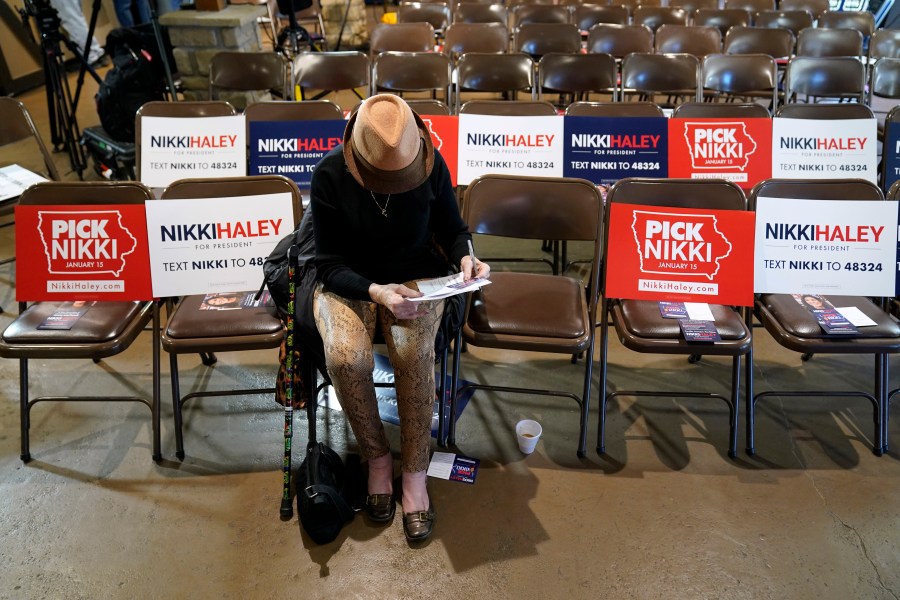 Sandra Sandfort, of Ames, Iowa, signs a commit to caucus card before a Republican presidential candidate Nikki Haley town hall, Monday, Dec. 18, 2023, in Nevada, Iowa. (AP Photo/Charlie Neibergall)