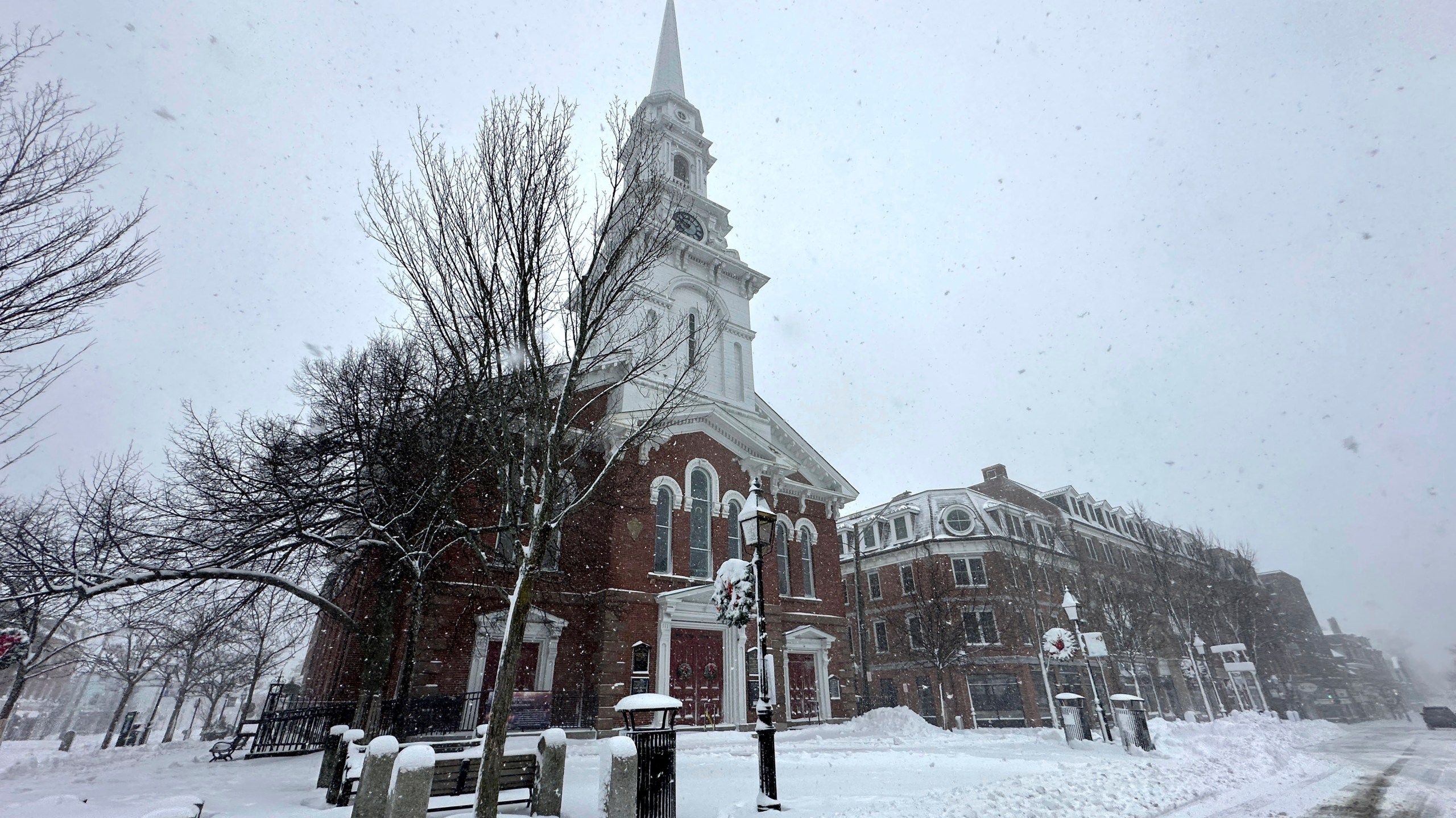 Snow falls in Portsmouth, N.H., Sunday, Jan. 7, 2024. A major winter storm bringing up to a foot of snow and freezing rain to some communities spread across New England Sunday sending residents scurrying to pull out their shovels and snow blowers to clear sidewalks and driveways. Winter storm warnings and watches were in effect throughout the Northeast, and icy roads made for hazardous travel as far south as North Carolina. (AP Photo/Caleb Jones)