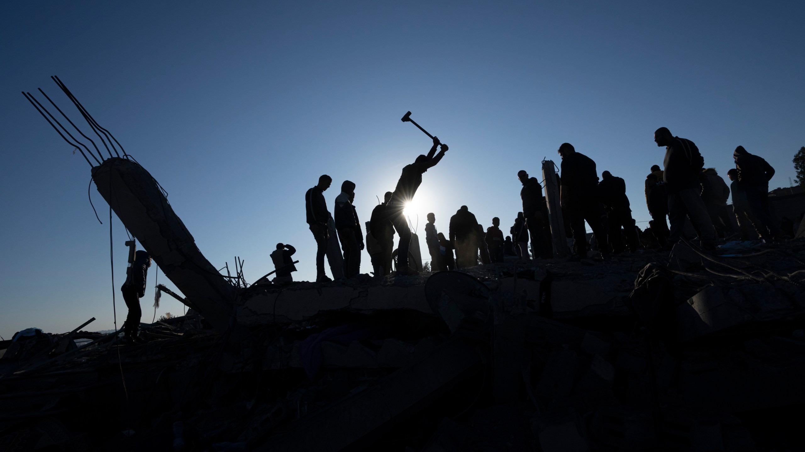 Palestinians search for bodies and survivors in the rubble of a house destroyed in an Israeli airstrike, in Rafah, southern Gaza Strip, Sunday, Jan. 7, 2024. (AP Photo/Fatima Shbair)