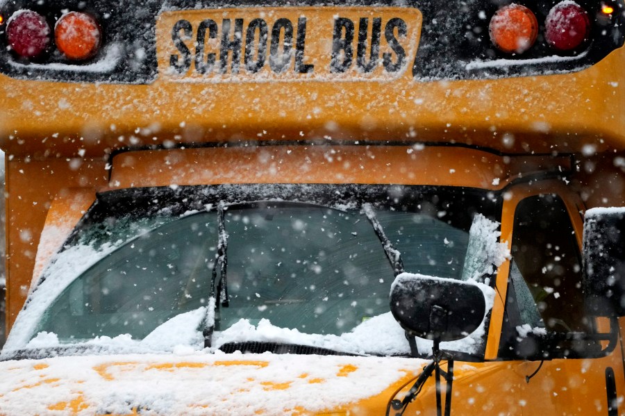 A school bus is driven along a snow-covered street during a heavy snow day in Wheeling, Ill., Tuesday, Jan. 9, 2024. (AP Photo/Nam Y. Huh)