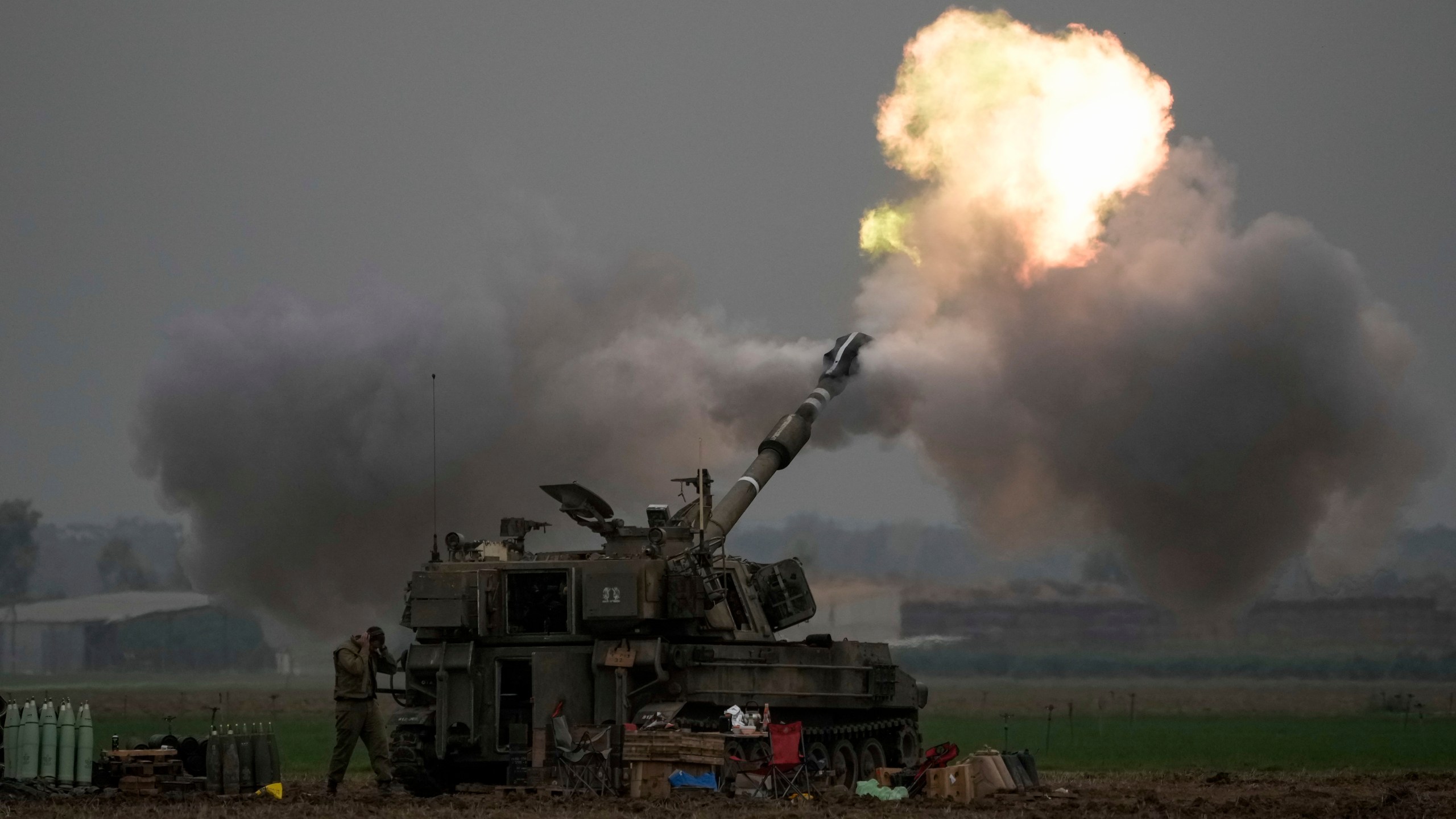 FILE - An Israeli mobile artillery unit fires a shell from southern Israel towards the Gaza Strip, in a position near the Israel-Gaza border on Thursday, Dec. 14, 2023. Israel is sending top legal minds, including a Holocaust survivor, to The Hague this week to counter allegations that it is committing genocide against Palestinians in Gaza. (AP Photo/Leo Correa, File)