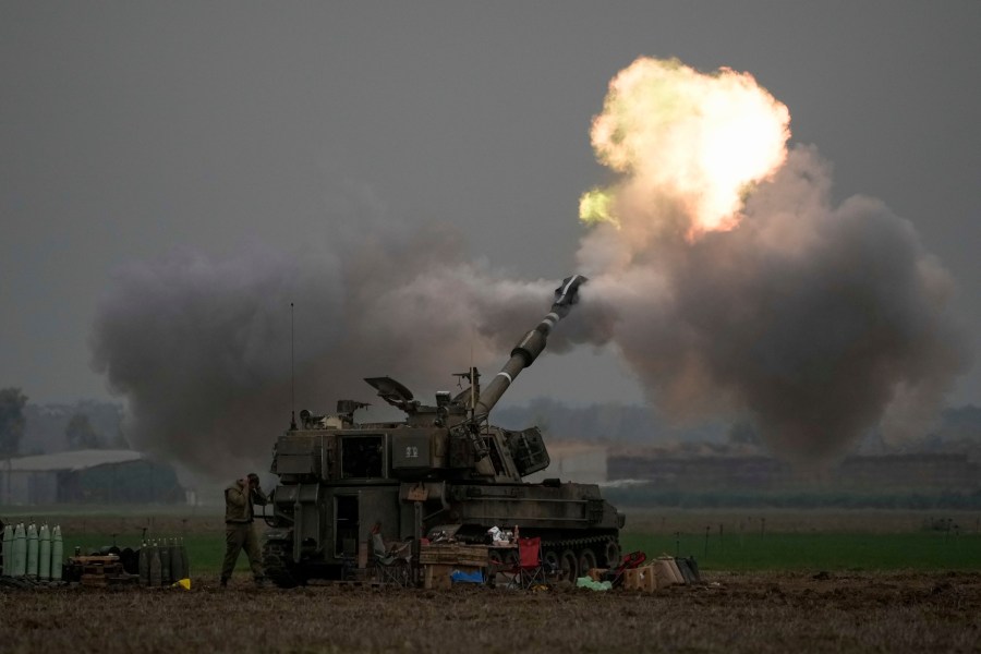 FILE - An Israeli mobile artillery unit fires a shell from southern Israel towards the Gaza Strip, in a position near the Israel-Gaza border on Thursday, Dec. 14, 2023. Israel is sending top legal minds, including a Holocaust survivor, to The Hague this week to counter allegations that it is committing genocide against Palestinians in Gaza. (AP Photo/Leo Correa, File)