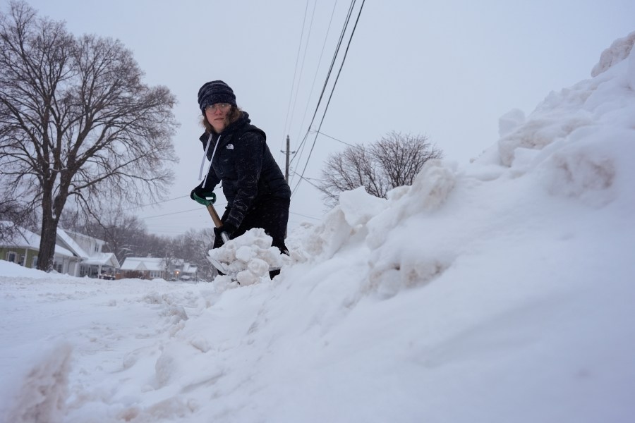 Graphic designer Emily Brewer shovels out her driveway in order to drive to work in Sioux City, Iowa, early on Friday, Jan. 12, 2024. (AP Photo/Carolyn Kaster)