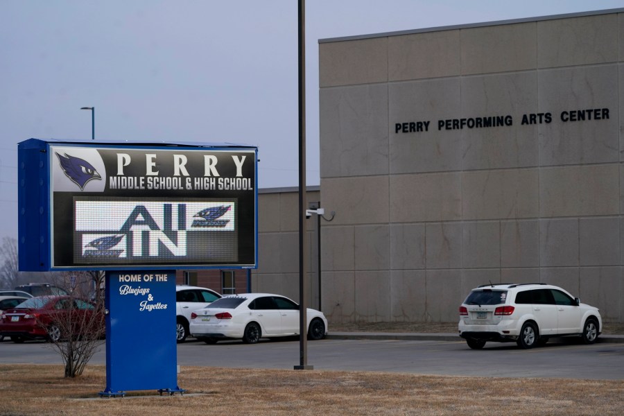 FILE - Vehicles are seen in a parking lot outside of Perry High School following a shooting at the school, Jan. 5, 2024, in Perry, Iowa. An Iowa principal who put himself in harm’s way to protect students during a school shooting earlier this month died Sunday, Jan. 14, 2024, a funeral home confirmed. Caldwell Parrish Funeral Home & Crematory confirmed the death of Perry High School Principal Dan Marburger after the family announced it on a GoFundMe page. (AP Photo/Charlie Neibergall, file)