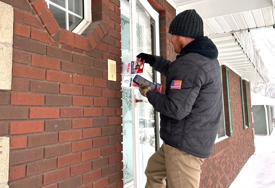 Drew Klein, a senior adviser with AFP Action, a group that has endorsed Nikki Haley, knocks on doors Jan. 13, 2024, in Urbandale, Iowa. Klein was one of more than 200 people working outdoors despite the frigid weather, in the days leading up to the Iowa caucuses to try to persuade undecided voters to support Haley. (AP Photo/Jill Colvin)