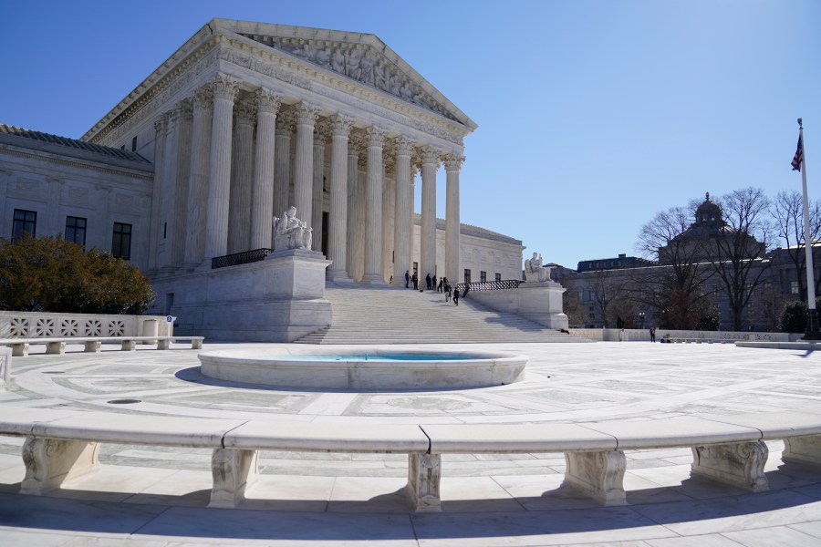 FILE - People stand on the steps of the U.S. Supreme Court, Feb.11, 2022, in Washington. The Supreme Court is taking up challenges by commercial fishermen to a fee requirement that could achieve a long-sought goal of business and conservative interests, limiting a wide range of government regulations. Billions of dollars are potentially at stake. (AP Photo/Mariam Zuhaib, File)