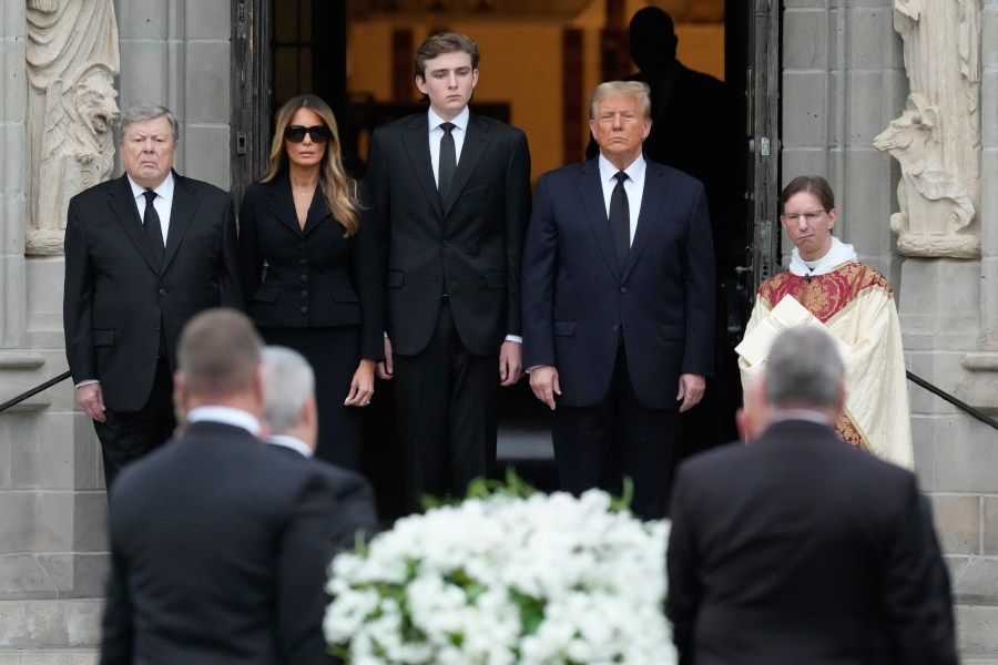 Former President Donald Trump, center right, stands with his wife Melania, second left, their son Barron, center left, and father-in-law Viktor Knavs, as the coffin carrying the remains of Amalija Knavs, the former first lady's mother, is carried into the Church of Bethesda-by-the-Sea for her funeral, Thursday, Jan. 18, 2024, in Palm Beach, Fla. (AP Photo/Rebecca Blackwell)