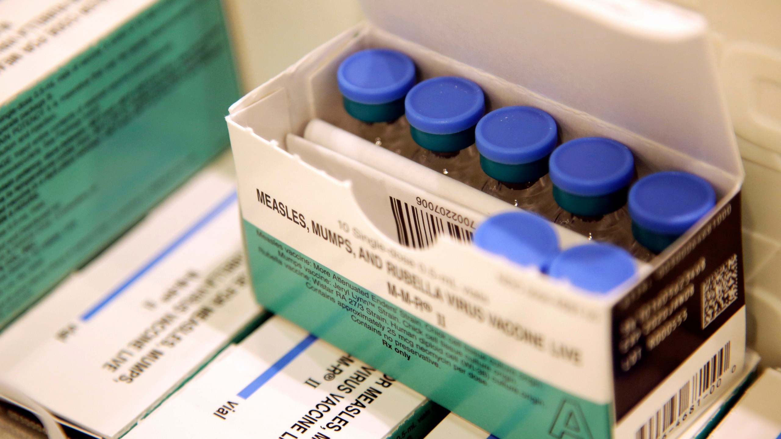 FILE- Vials of measles, mumps and rubella vaccine sit in a cooler at the Rockland County Health Department in Pomona, N.Y., March 27, 2019. A midwife on New York's Long Island, who gave nearly 1,500 children homeopathic pellets instead of required vaccinations, has been fined $300,000, the state's health department announced this week. (AP Photo/Seth Wenig, File)