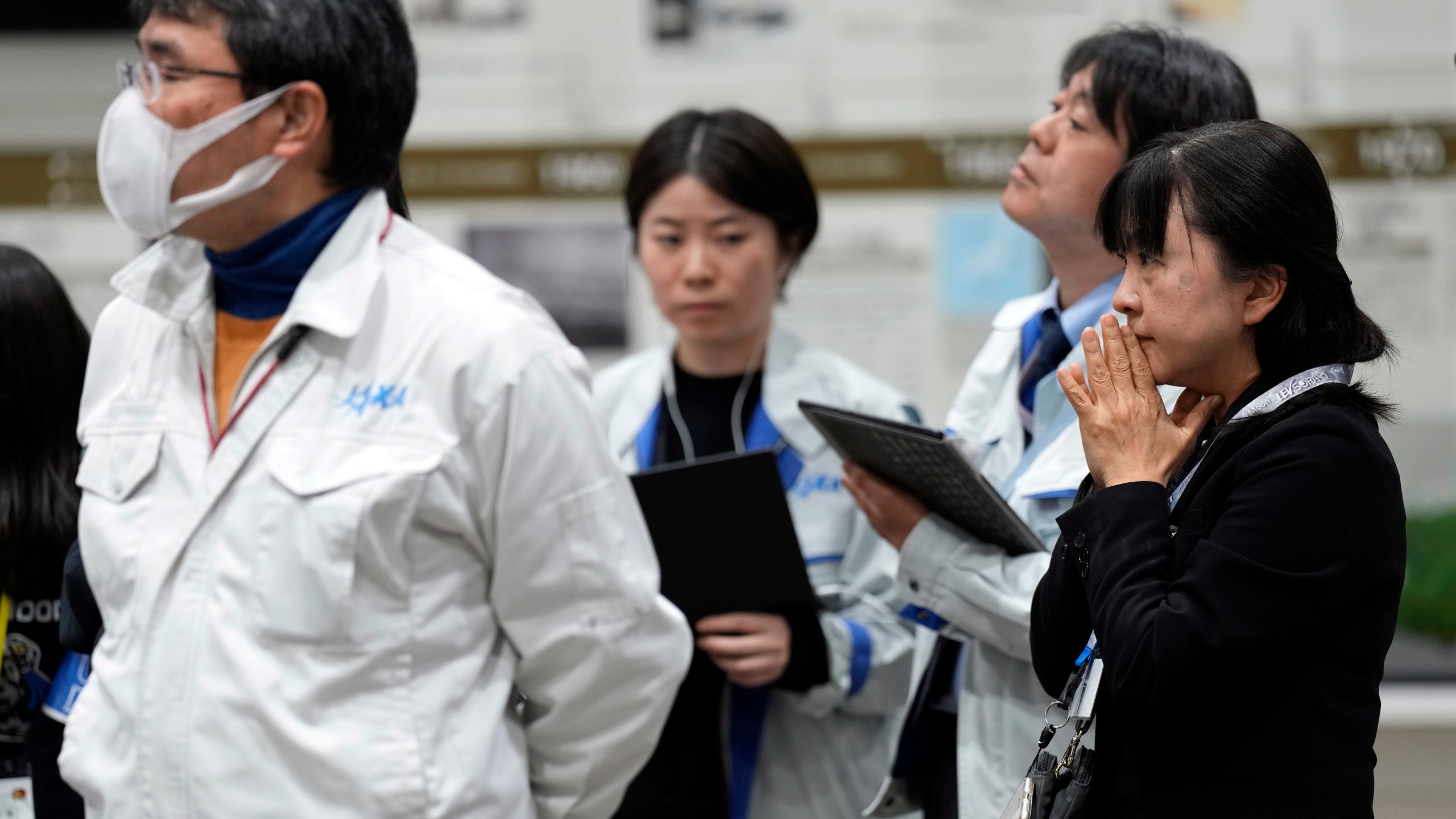 Staff of Japan Aerospace Exploration Agency (JAXA) watch a live streaming of the pinpoint moon landing operation by the Smart Lander for Investigating Moon (SLIM) spacecraft at JAXA's Sagamihara Campus Saturday, Jan. 20, 2024, in Sagamihara near Tokyo. (AP Photo/Eugene Hoshiko)