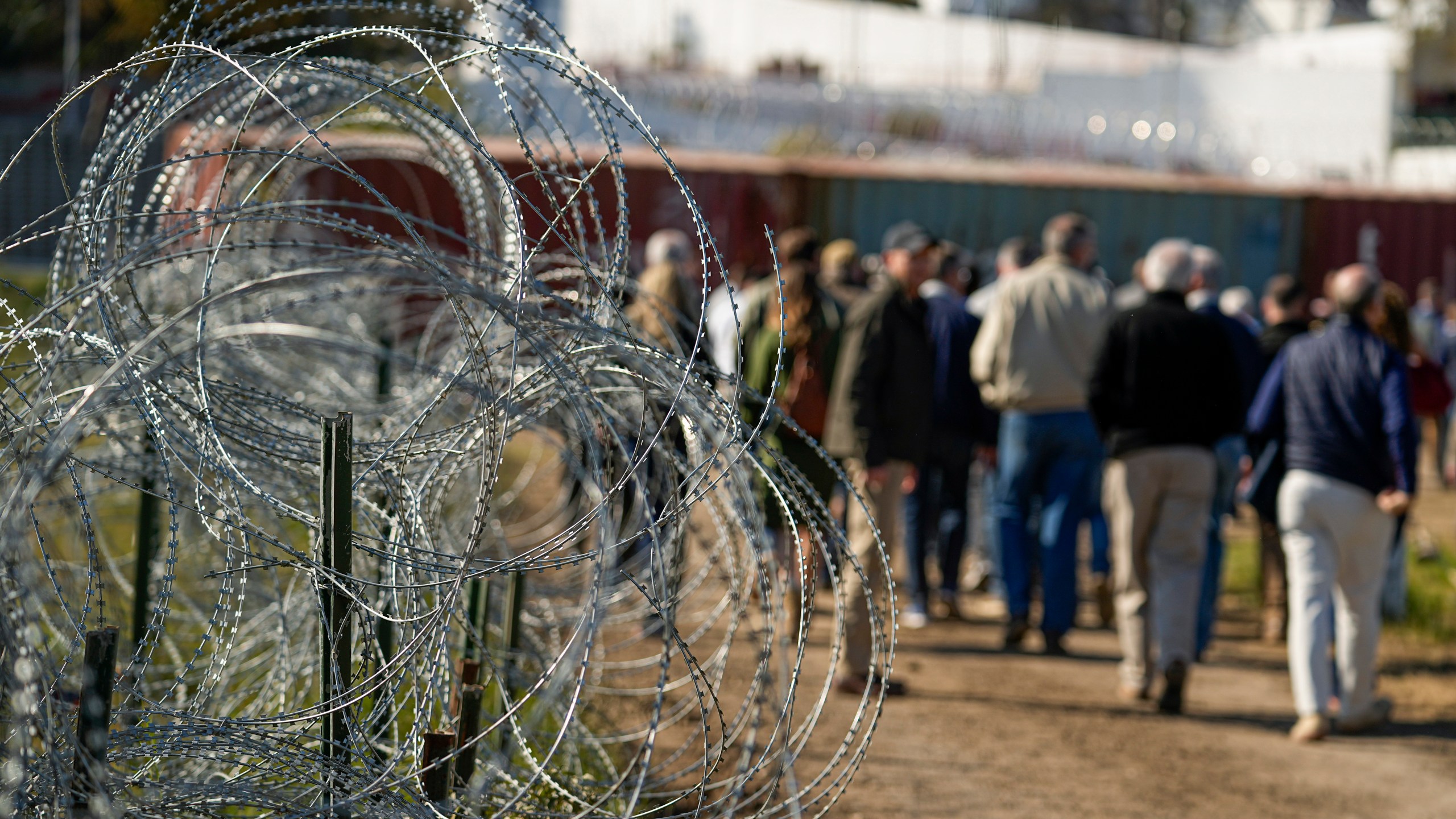 FILE - Concertina wire lines the path as members of Congress tour an area near the Texas-Mexico border, Jan. 3, 2024, in Eagle Pass, Texas. As congressional negotiators try to finalize a bipartisan deal on the border and immigration, their effort is drawing the wrath of hard-right lawmakers and former President Donald Trump. That vocal opposition threatens to unravel a delicate compromise. (AP Photo/Eric Gay, File)