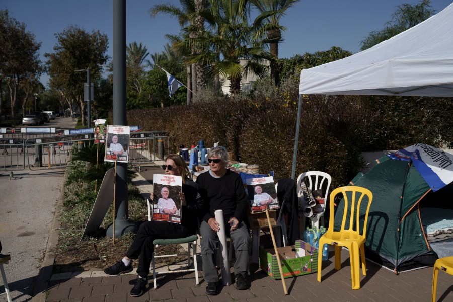 Relatives and friends of hostages sit on a camp set up outside the private residence of the Israeli Prime Minister Benjamin Netanyahu, in Caesarea, Israel, Saturday, Jan. 20, 2024, in support of a father of an Israel hostage held in Gaza who has begun a hunger strike to protest the government's lack of visible progress on a new hostage deal. (AP Photo/Leo Correa)