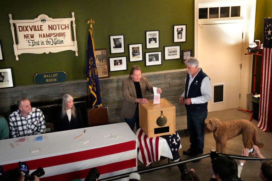 Les Otten, far right, has his vote inserted into the ballot box by town moderator Tom Tillotson shortly after midnight in the presidential primary election, Tuesday, Jan. 23, 2024, in Dixville Notch, N.H. All six voters selected Nikki Haley. (AP Photo/Robert F. Bukaty)