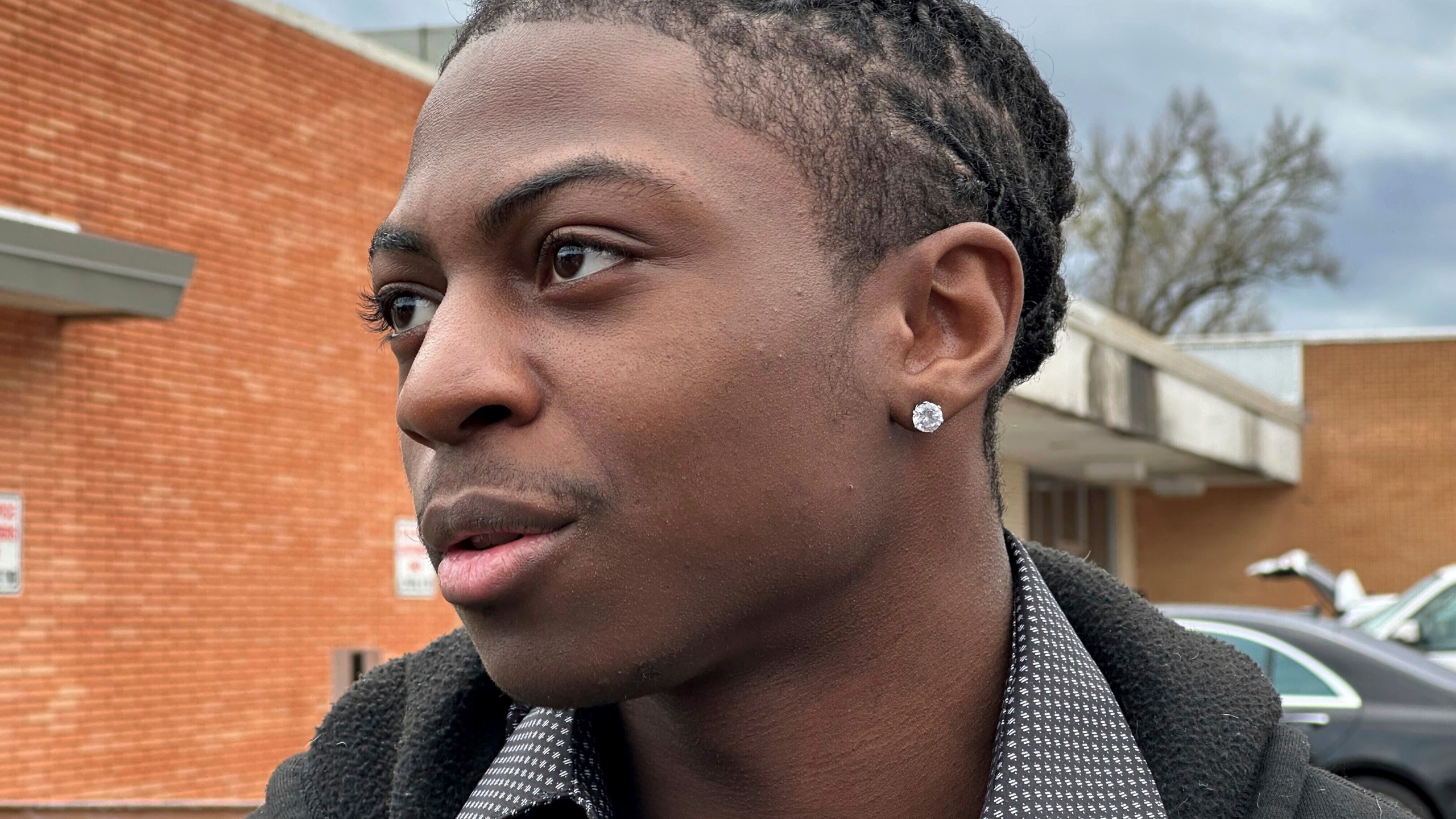 Darryl George, an 18-year-old high school junior, stands outside a courthouse in Anahuac, Texas, on Wednesday, Jan. 24, 2024. A judge ordered Wednesday that a trial be held next month to determine whether George can continue being punished by his district for refusing to change a hairstyle he and his family say is protected by a new state law. (AP Photo/Juan A. Lozano)