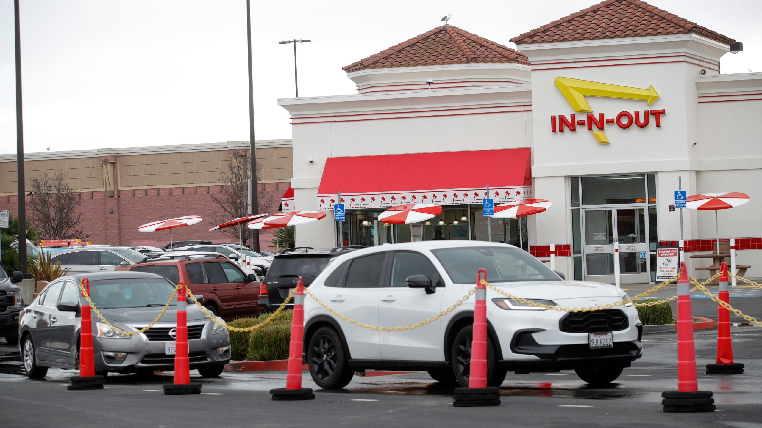 Customers line up at the In-N-Out drive-thru off Hegenberger Road in Oakland, Calif., on Monday, Jan. 22, 2024. In-N-Out will close its only restaurant in Oakland because of a wave of car break-ins, property damage, theft and armed robberies targeting customers and employees alike, the company announced. The burger joint in a busy corridor near the Oakland International Airport will close on March 24, 2024. (Jane Tyska/Bay Area News Group via AP)