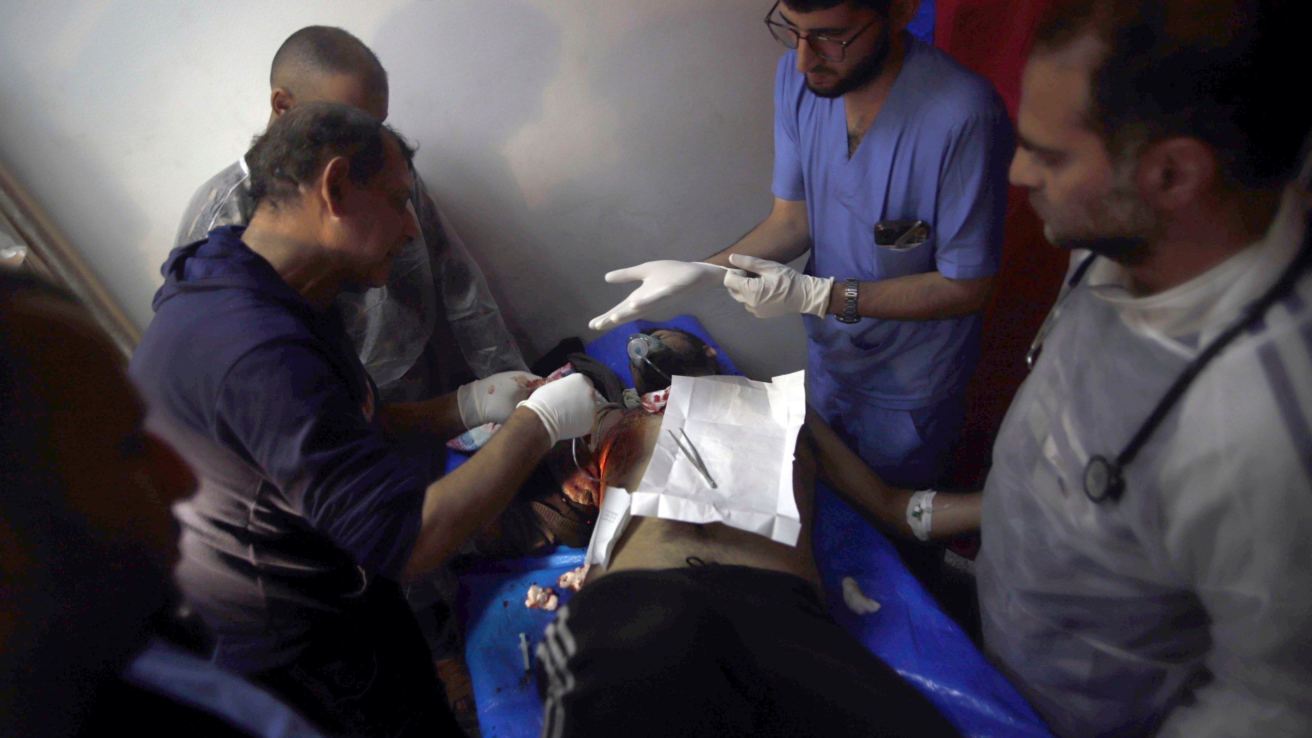 Palestinian medics treat a man wounded in the Israeli bombardment at a building of an UNRWA vocational training center which displaced people use as a shelter in Khan Younis, southern Gaza Strip, Wednesday, Jan. 24, 2024. (AP Photo/Ramez Habboub)