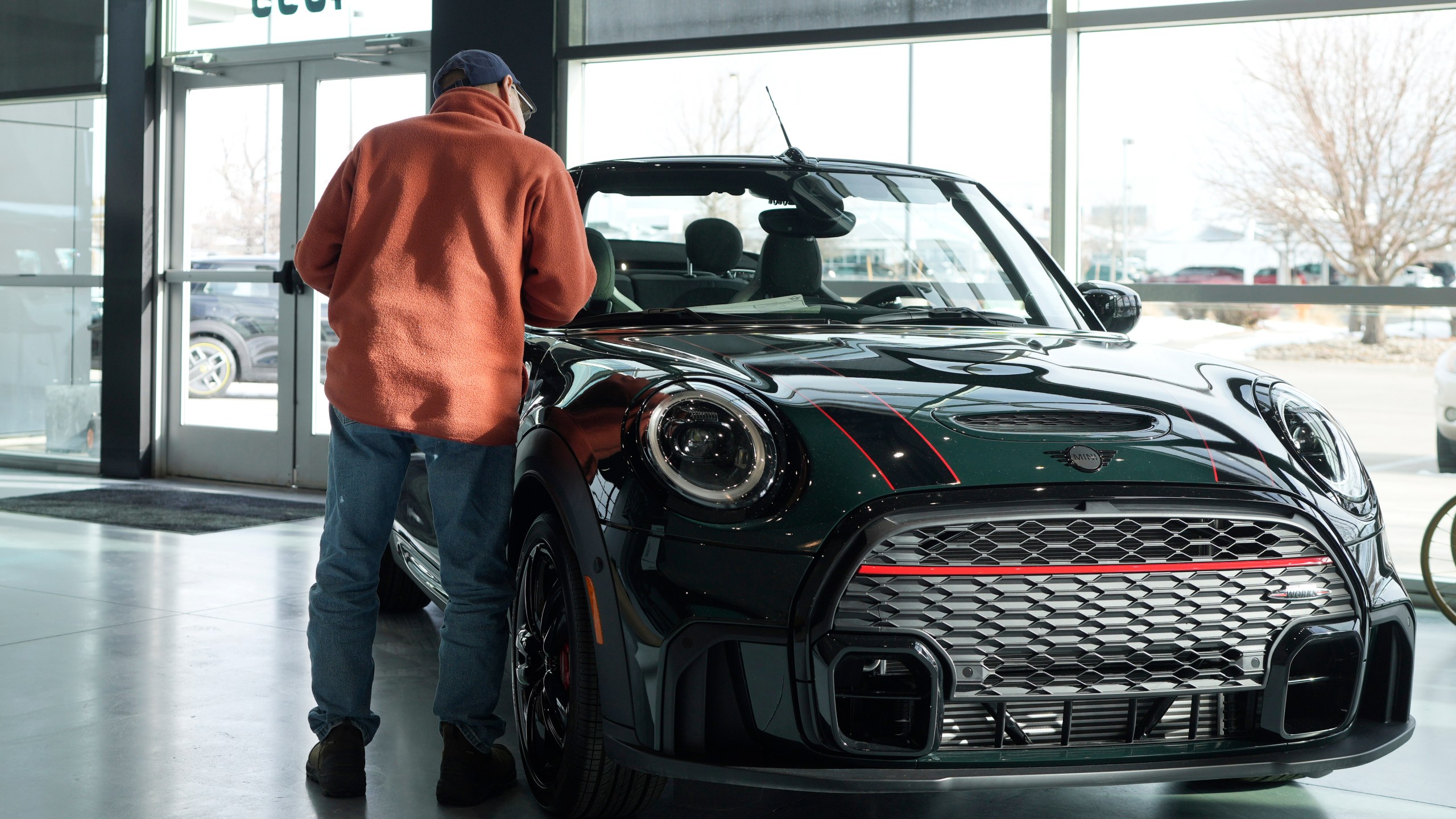 File - A customer looks over an unsold 2024 Cooper S John Cooper Works convertible on the showroom floor of a Mini dealership on Nov. 30, 2023, in Loveland, Colo. On Tuesday, Jan. 30, 2024, the Conference Board reports on U.S. consumer confidence for January. (AP Photo/David Zalubowski, File)