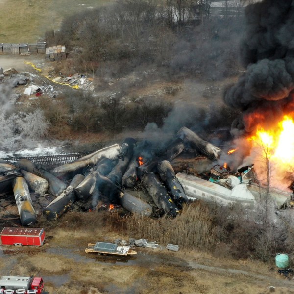 FILE - Portions of a Norfolk Southern freight train that derailed the night before burn in East Palestine, Ohio, Feb. 4, 2023. The White House says President Joe Biden will visit the eastern Ohio community that was devastated by a fiery train derailment in February 2023. (AP Photo/Gene J. Puskar, File)