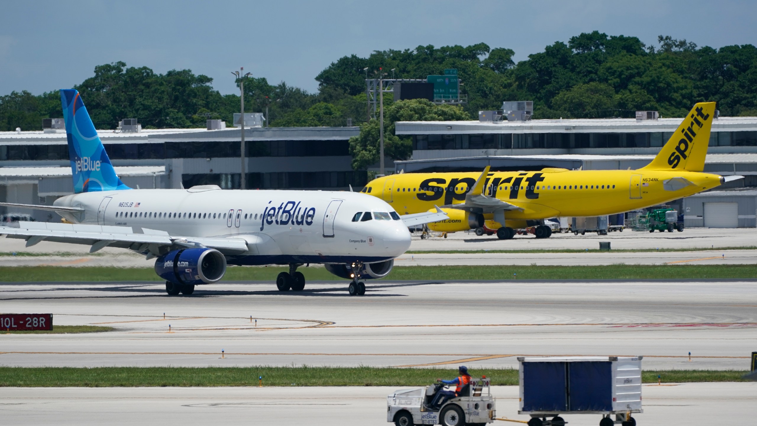 FILE - A JetBlue Airways Airbus A320, left, passes a Spirit Airlines Airbus A320 as it taxis on the runway, July 7, 2022, at the Fort Lauderdale-Hollywood International Airport in Fort Lauderdale, Fla. JetBlue Airways warned Friday, Jan. 26, 2024, that it might end its attempt to buy low-cost carrier Spirit Airlines as soon as this weekend, sending Spirit shares lower. (AP Photo/Wilfredo Lee, File)