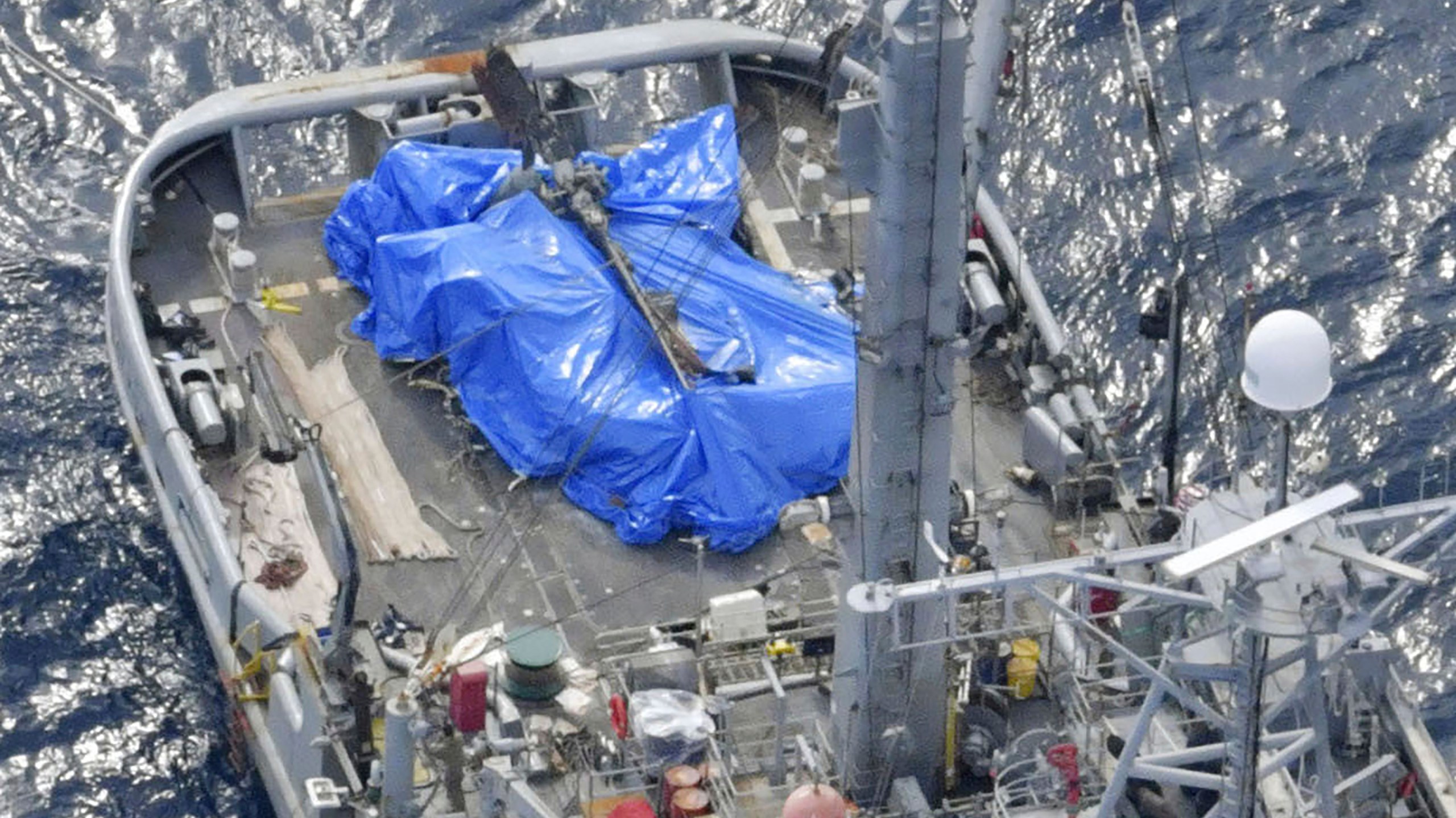 A blue sheet covers what believed to be a part of a crashed U.S. military Osprey aircraft on a U.S. salvage boat off Yakushima, Kagoshima prefecture, southern Japan on, Dec. 27, 2023. The U.S. Air Force on Friday, Jan. 12, 2024 announced the end of its more than a month long search and recovery operation at the site of a CV-22B Osprey crash that occurred off the southern Japanese coast in late November, expressing regret at not being able to find the last of the eight crew members killed. (Kyodo News via AP)