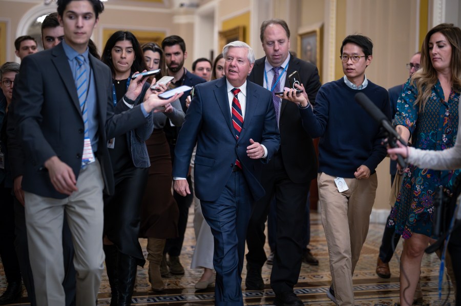 With reporters seeking comment, Sen. Lindsey Graham, R-S.C., walks to the chamber during a test vote to begin debate on a border security bill, at the Capitol in Washington, Wednesday, Feb. 7, 2024. (AP Photo/J. Scott Applewhite)