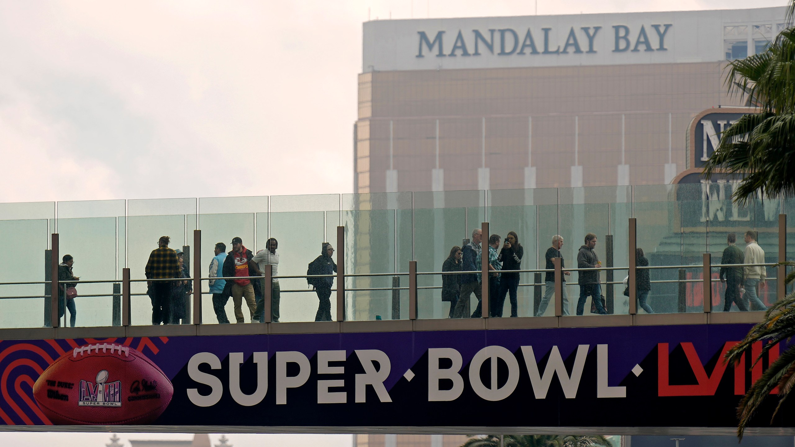 People cross a bridge over the Las Vegas strip Tuesday, Feb. 6, 2024 in Las Vegas. The city will host the Kansas City Chiefs and the San Francisco 49ers in the NFL's Super Bowl 58 football game Sunday. (AP Photo/Charlie Riedel)