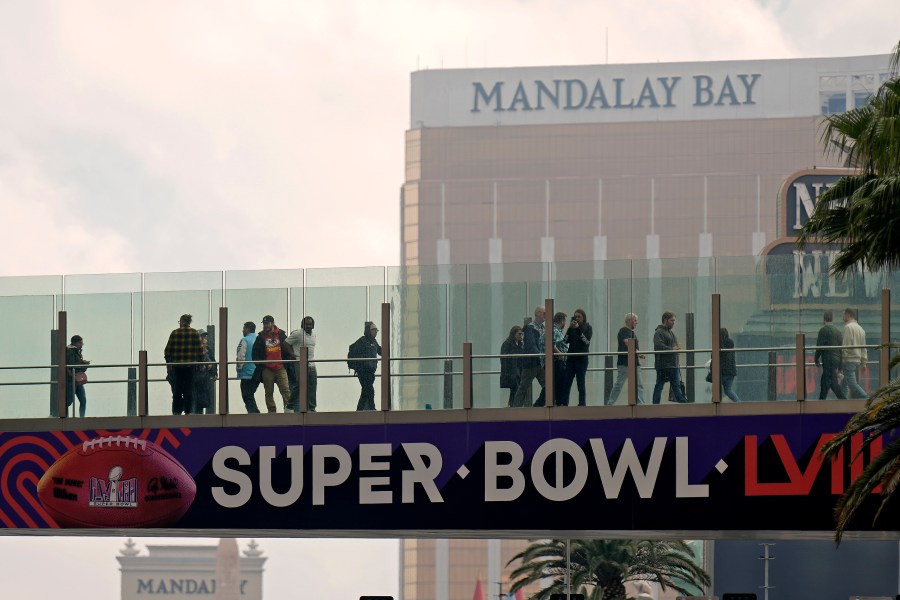 People cross a bridge over the Las Vegas strip Tuesday, Feb. 6, 2024 in Las Vegas. The city will host the Kansas City Chiefs and the San Francisco 49ers in the NFL's Super Bowl 58 football game Sunday. (AP Photo/Charlie Riedel)