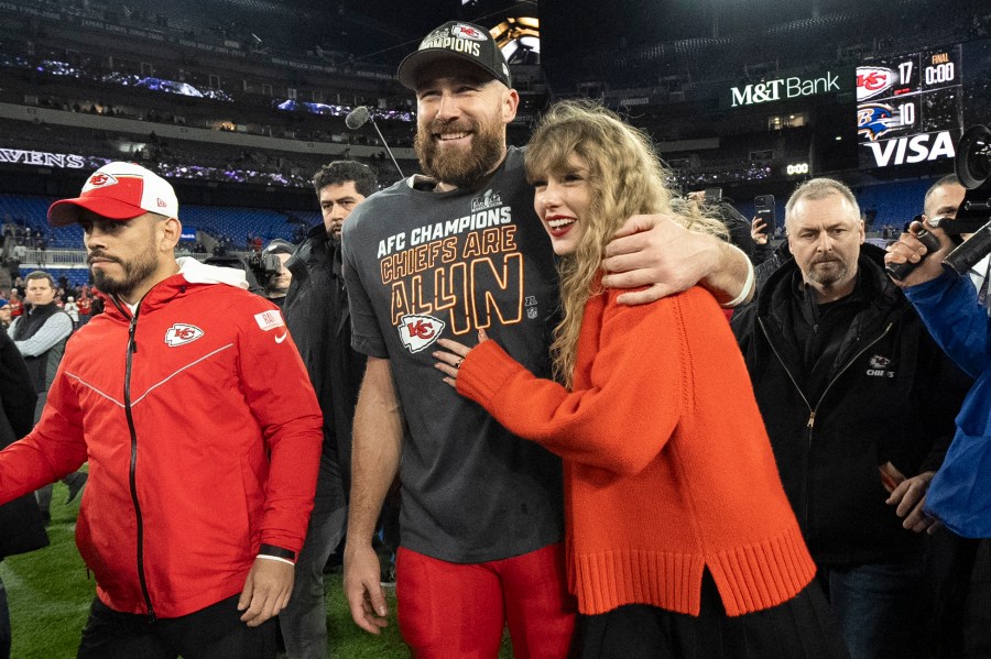 ARCHIVO - El tight end de los Chiefs de Kansas City Travis Kelce camina con Taylor Swift tras el campeonato de la AFC ante los Ravens de Baltimore el domingo 28 de enero de 2024, en Baltimore. (Foto AP/Julio Cortez, archivo)