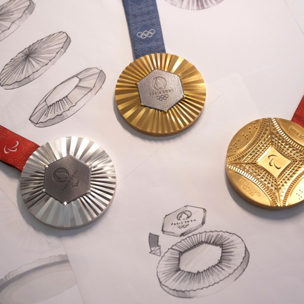 The Paris 2024 Olympic gold medal, center, the Paris 2024 Paralympic, gold medal, right, and silver medal, left, are presented to the press, in Paris, Thursday, Feb. 1, 2024. A hexagonal, polished piece of iron taken from the Eiffel Tower is being embedded in each gold, silver and bronze medal that will be hung around athletes' necks at the July 26-Aug. 11 Paris Games and Paralympics that follow. (AP Photo/Thibault Camus)