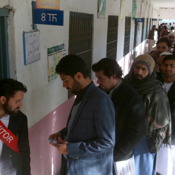 People stand in queue as they wait for their turn to cast vote outside a polling station during the country's parliamentary elections in Jamrud, in the Khyber district, Pakistan, Thursday, Feb. 8, 2024. Pakistanis lined braved cold winter weather and the threat of violence to vote for a new parliament Thursday, a day after twin bombings claimed at least 30 lives in the worst election-related violence ahead of the contested elections. (AP Photo/Muhammad Sajjad)