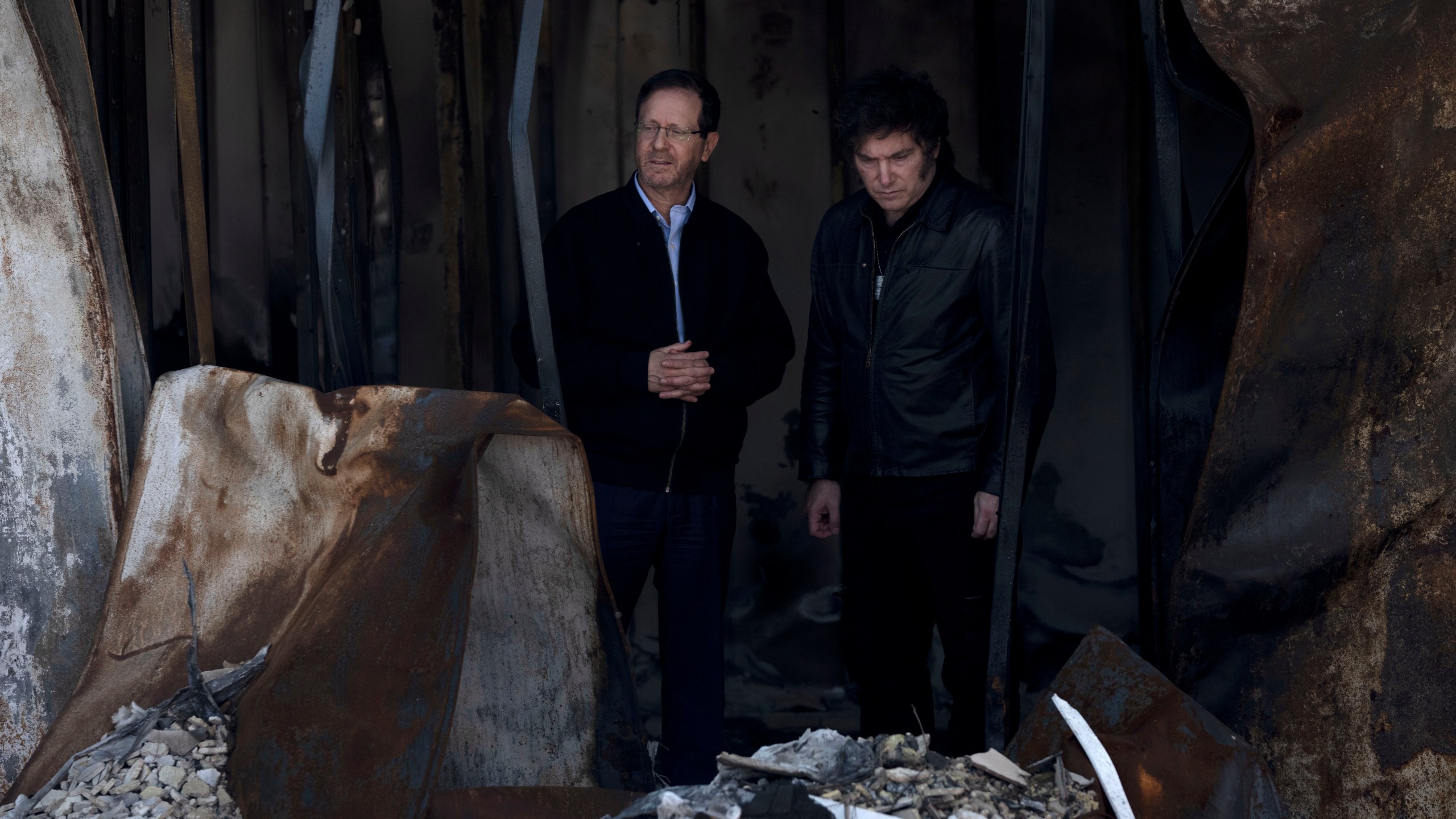 Argentina's President Javier Milei, right, and Israel's President Isaac Herzog, left, visit the ruins of a home on Thursday, Feb. 8, 2024, at Kibbutz Nir Oz, where Hamas killed or kidnapped a quarter of the community on Oct. 7, 2023. (AP Photo/Maya Alleruzzo)